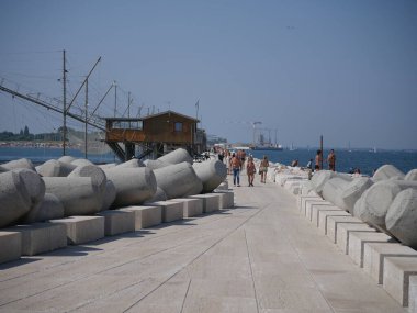 Sottomarina, Diga sahilden fenere yürüme yolu olan bir Istrian taş iskelesi. İskele boyunca ahşap balıkçı makineleri var..