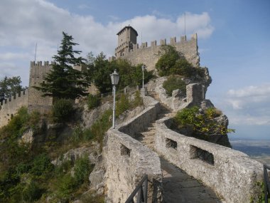 San Marino, Cadıların Geçidi. Merdiveni kayanın içine oyulmuş ilk kuleye doğru uzanan yolun panoraması çevreyi ve denizi gören bir kayanın üzerine tünemiş. 