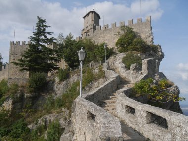 San Marino, Cadıların Geçidi. Merdiveni kayanın içine oyulmuş ilk kuleye doğru uzanan yolun panoraması çevreyi ve denizi gören bir kayanın üzerine tünemiş. 