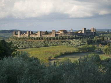 Monteriggioni Kalesi 'nin panorama' sı. Etrafı kırsal ve zeytinliklerle çevrili bir tepenin tepesinde 14 kuleli dairesel çevre duvarları var.