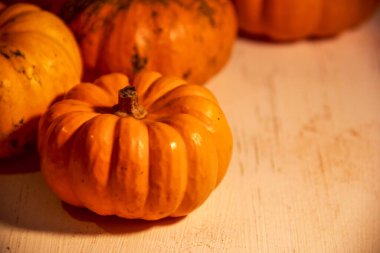 Turuncu balkabakları açık ahşap bir yüzeyde yatar.