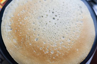 Elektrikli tavada büyük yuvarlak gözleme.