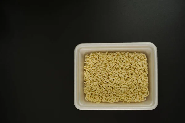 Ξηρά στιγμιαία noodles σε ορθογώνιο πλαστικό πιάτο, πάνω όψη — Φωτογραφία Αρχείου
