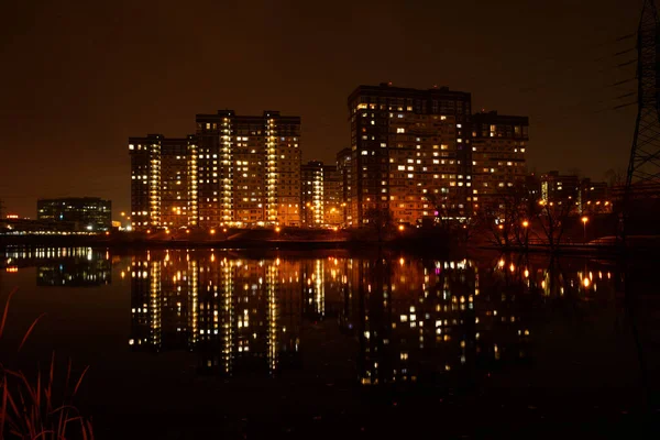 Visão noturna de edifícios com reflexão na lagoa — Fotografia de Stock