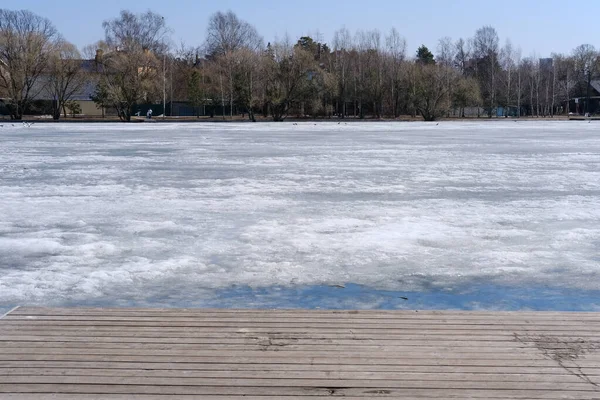 Dřevěné molo pokryté sněhem u zamrzlého jezera — Stock fotografie