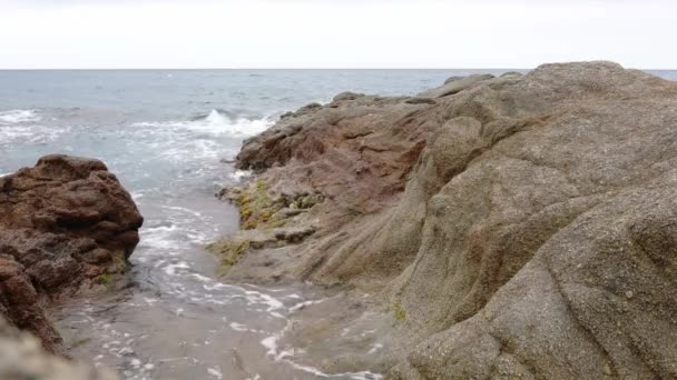 Tengerhullámok zuhannak le sziklákon a partvonal közelében — Stock videók