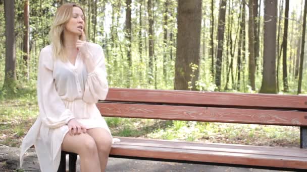 Молода красива довгошерста блондинка влітку на природі — стокове відео