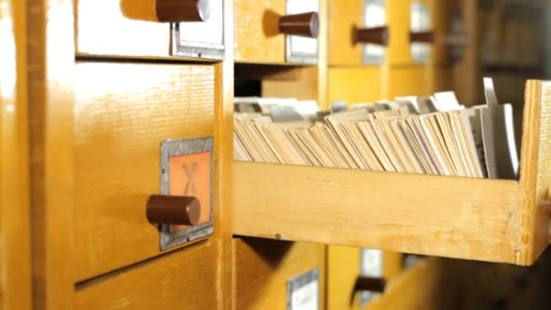 Hombre buscando un libro en el catálogo de tarjetas de la biblioteca — Vídeo de stock