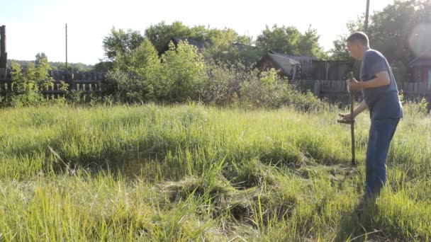 Dorpsbewoner maait het gras in uw hand — Stockvideo