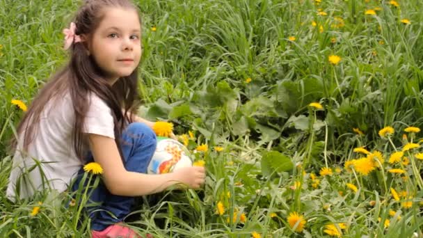 Маленькая девочка собирает одуванчики — стоковое видео