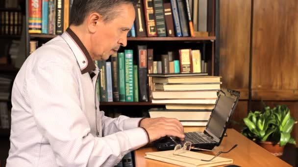 Hombre escribiendo y estudiando en la biblioteca — Vídeos de Stock