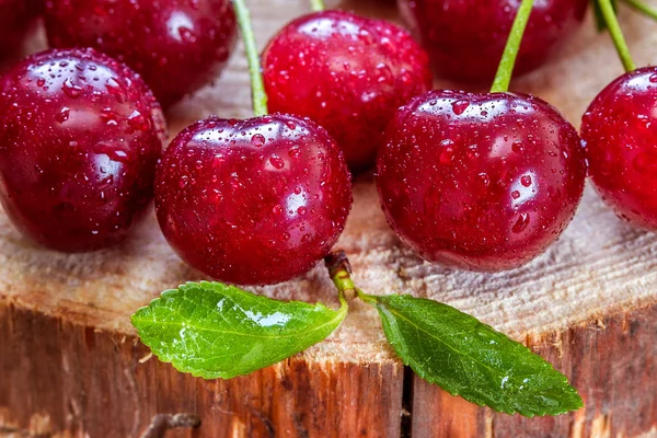 Cerises rouges, joyeux tas sur fond en bois — Photo