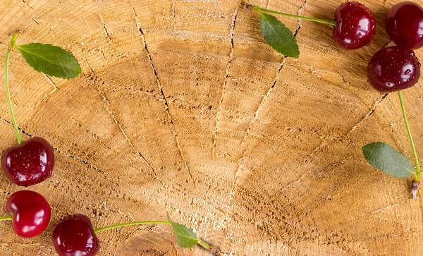 Cerises fraîches sur une table en bois — Photo