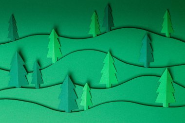 3D, yeşil arka planda noel ağacı kağıtları çıkarıyor. kağıt kesim tasarım kartı.