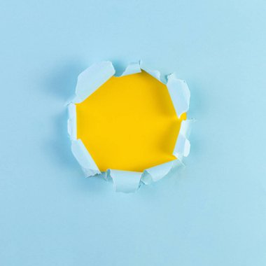 Sarı arka planı olan yırtık Kağıt Delik. Mavi kağıtta yırtık bir delik, yırtık kenarlar. Tasarımınız için alanı kopyalayın.