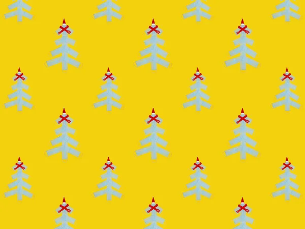 Kerstboom gemaakt van medische gezichtsmaskers op gele papieren achtergrond. Kerstmis naadloos patroon — Stockfoto