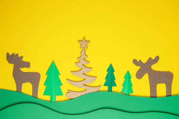 Yılbaşı ağacı kağıdı tasarım kağıdı kesiyor. Kağıt Noel ağacı ve geyik keser.. — Stok fotoğraf