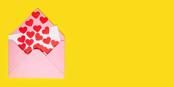 バレンタインデーカード。紙の赤い心は黄色の背景にピンクの紙の封筒の外に飛ぶ。バレンタインデーの紙アート. — ストック写真