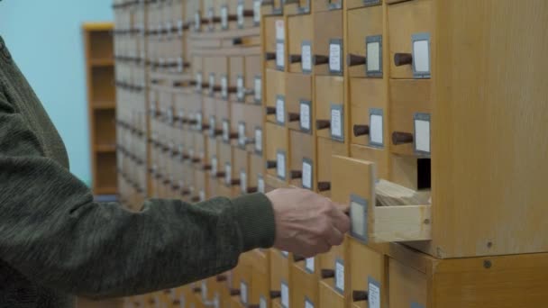 Eine männliche Hand sucht Karten im alten Holzkartenkatalog. — Stockvideo