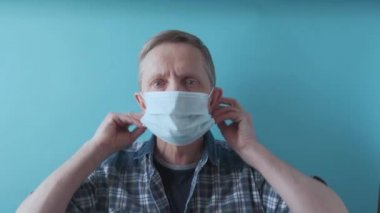 Yaşlı bir adam salgına karşı cerrahi maske takıyor. 4k görüntü