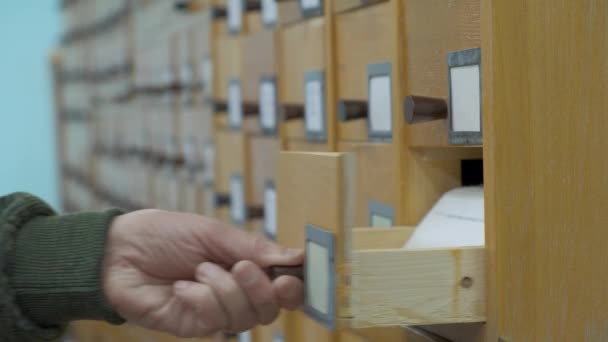 Eine männliche Hand sucht Karten im alten Holzkartenkatalog. 4k Filmmaterial — Stockvideo