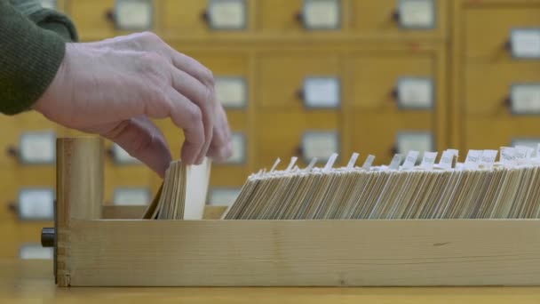 Een mannelijke handzoekkaart in oude houten kaartencatalogus. 4k-beelden. — Stockvideo