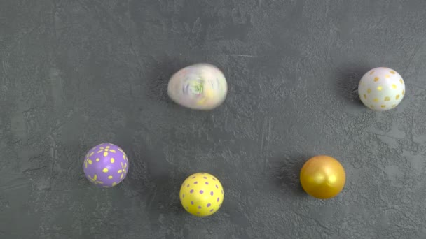 暗いコンクリートテーブルの上を転がるイースターカラフルな卵。こんにちは春とイースターのコンセプト。4kビデオ — ストック動画