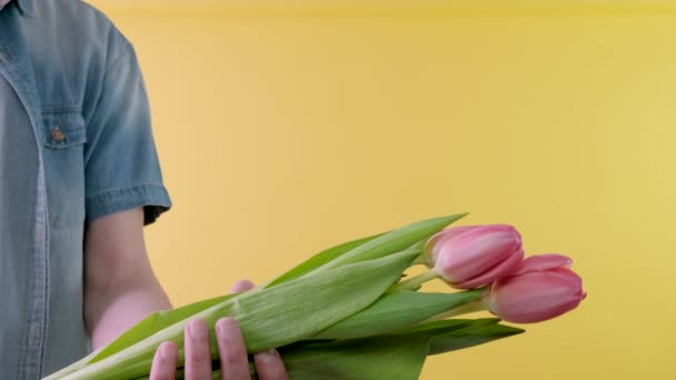 Букет тюльпанов. Человек с букетом тюльпанов. Манская рука дарит букет цветов. — стоковое видео