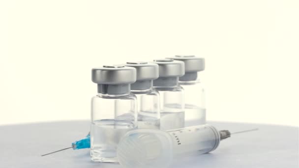 Spuiten en injectieflacons met vaccin van het virus covid 19. rotatie 360 graden. 4k — Stockvideo
