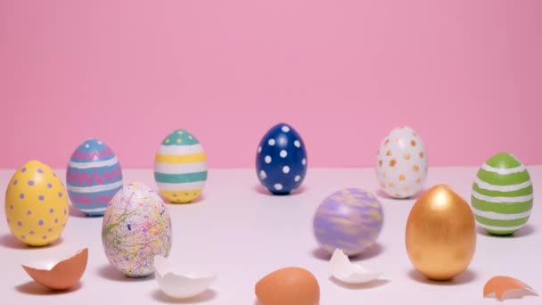 Coloridos huevos de Pascua en la mesa rosa. Huevos coloreados sobre un fondo rosa. — Vídeo de stock