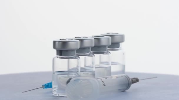 Injekční stříkačky a injekční lahvičky vakcíny z viru covid 19. rotace 360 stupňů. 4k — Stock video