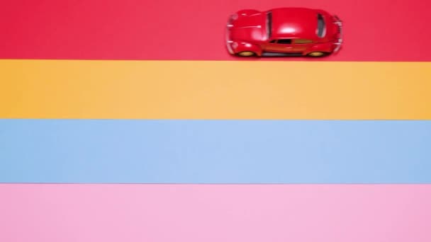 Piccole auto vintage retrò giocattolo su uno sfondo rosa, giallo, blu. — Video Stock