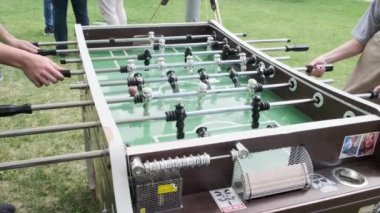 Langırt oynayan insanlar. Arkadaşlar birlikte masa futbolu oynayarak eğleniyor..