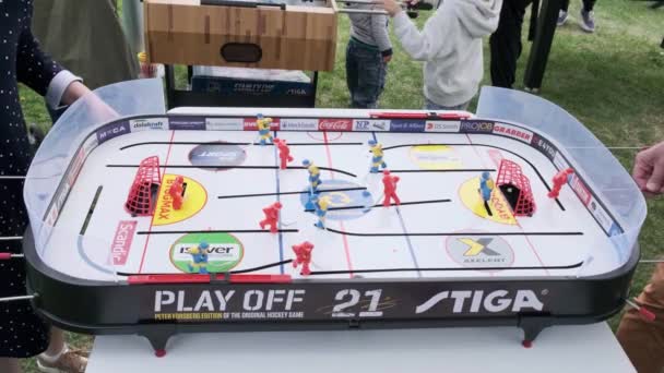 Люди грають у хокей на столах у парку, на вулиці. Людина грає в хокей на столах. — стокове відео