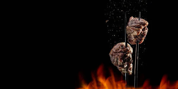 Вилка з шматочками смачного м'яса барбекю на чорному тлі . — стокове фото