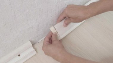Zanaatkar plastik süpürgeliğin ucuna dekoratif bir kapak takar.