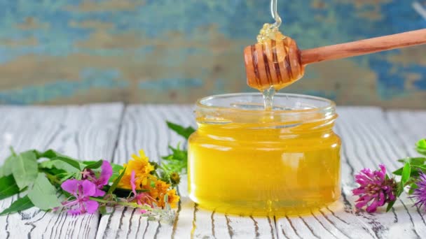 4k. Med ve skleněné sklenici s medovým držákem přes rustikální dřevěné pozadí — Stock video