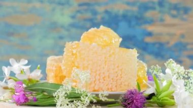 4 bin. Taze ballı bal petekleri kırsal arka planda yavaşça döner.