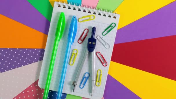 Fournitures de bureau scolaire sur fond de papier coloré. Rotation à 360 degrés — Video