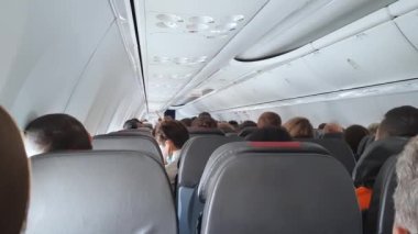 4 bin. Koltuklarda oturan insanlarla dolu bir yolcu uçağının kabini..
