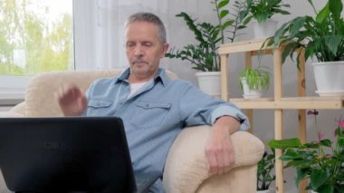 Bilgisayarlı bir adam Aileyle görüntülü konuşma yapıyor.