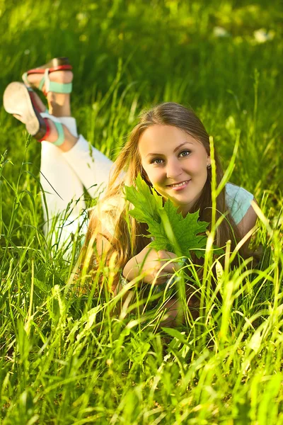 Mädchen liegt auf grünem Gras — Stockfoto