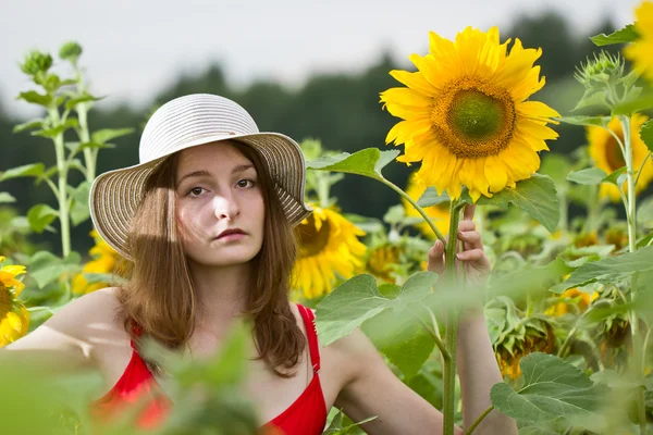 A menina em um campo com girassóis — Fotografia de Stock