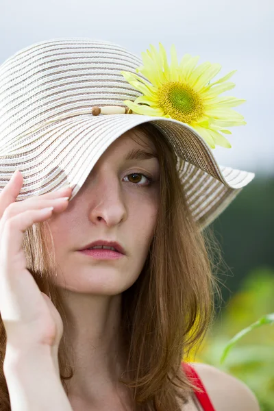 Mädchen mit Hut und Sonnenblume — Stockfoto