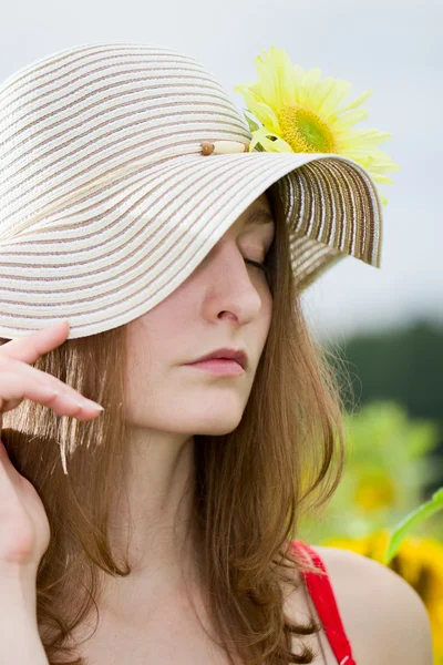 Junges Mädchen mit Hut und Sonnenblume — Stockfoto