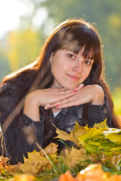 Girl lying on autumn leaves — Stock Photo, Image