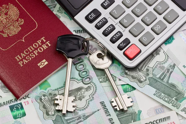 Паспорт, ключи и калькулятор на фоне денег — стоковое фото