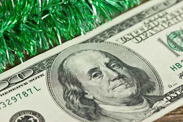 US hundred dollar bill with green Christmas tinsel — Stock Photo, Image