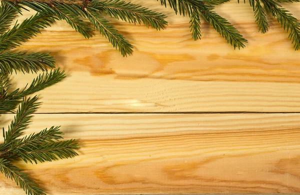 Rama de abeto sobre fondo de madera como marco — Foto de Stock