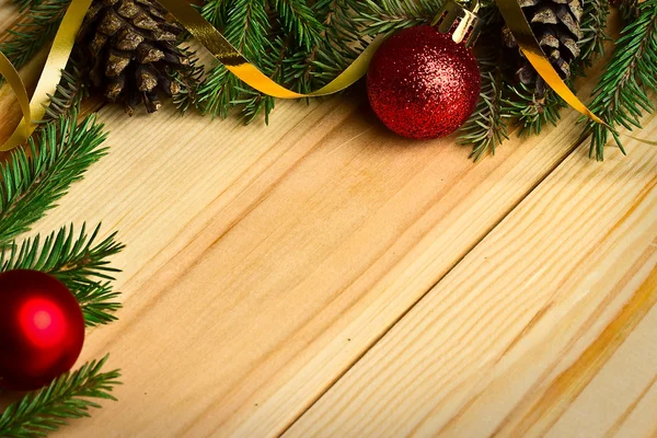 Las ramas de abeto y las bolas de Navidad sobre un fondo de madera — Foto de Stock